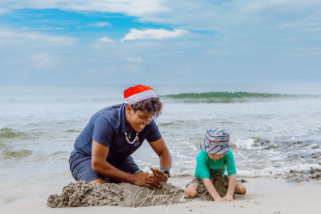 An Odyssey guide building a sandcastle with a young guest