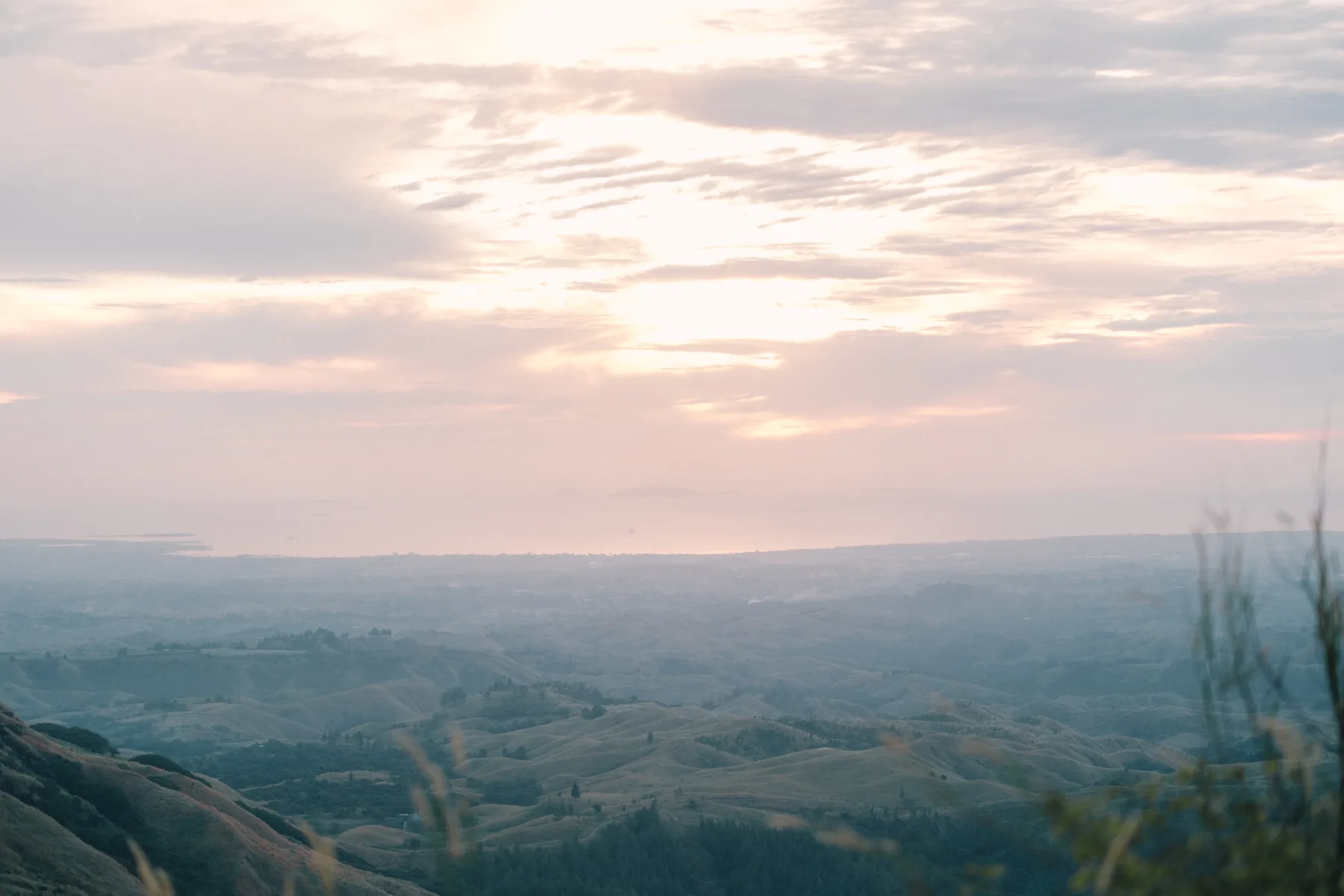 Morning light over layered green ridges and valleys
