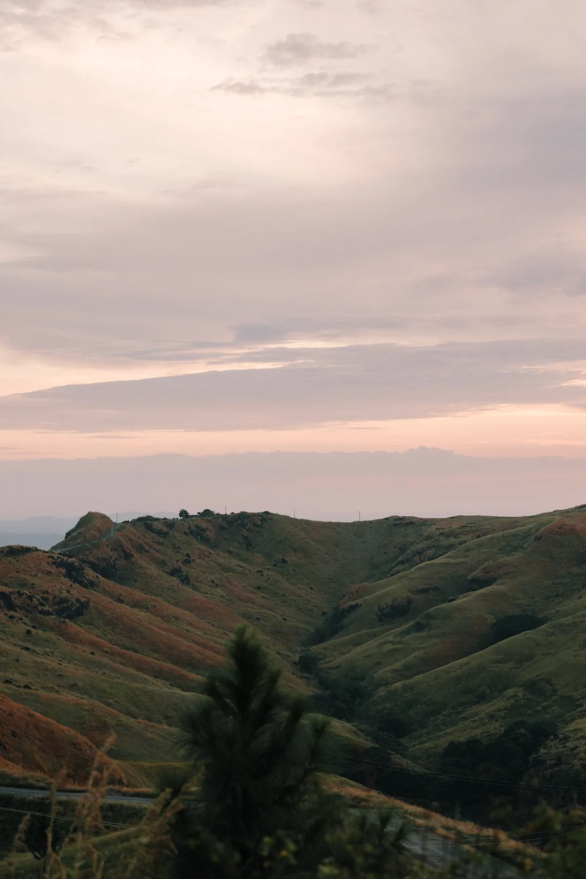 Rolling highland ridges under a pink evening sky