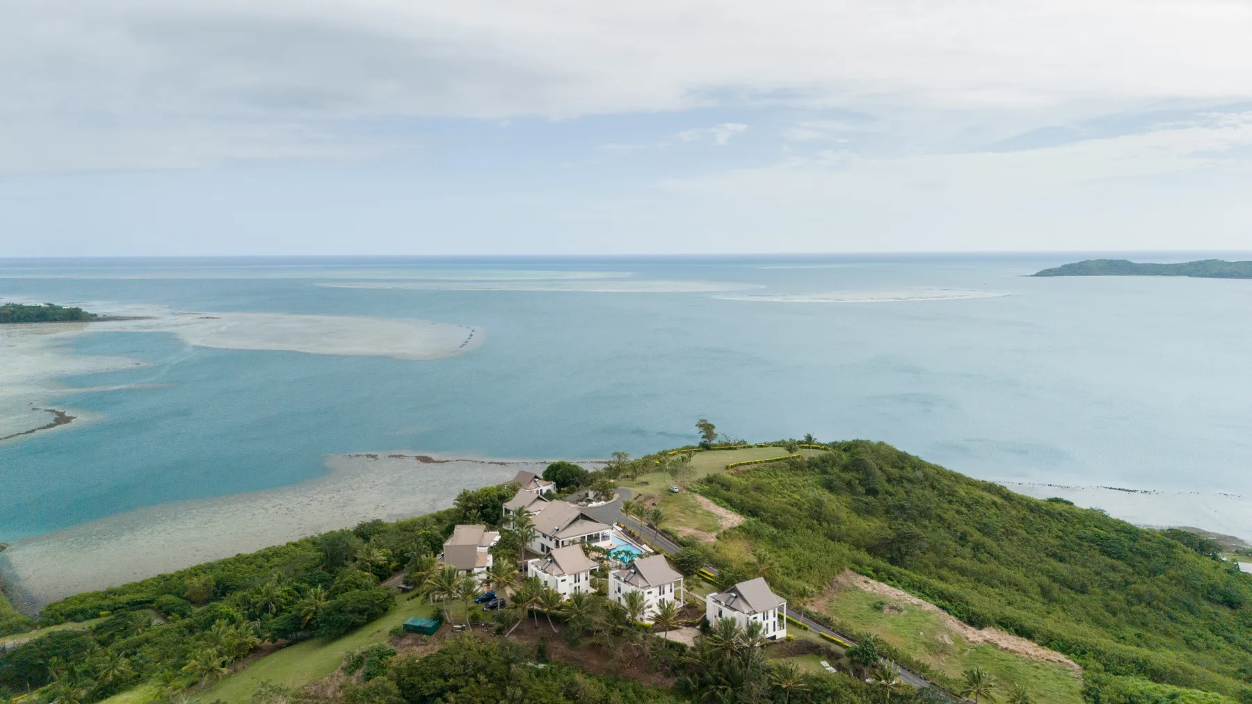 An island headland and reef-fringed coast from above