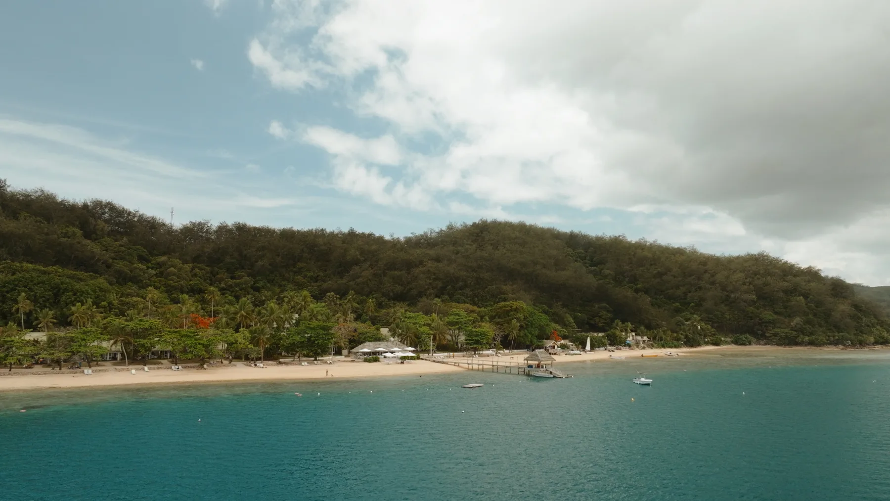 A sheltered island shoreline with clear blue water viewed from above